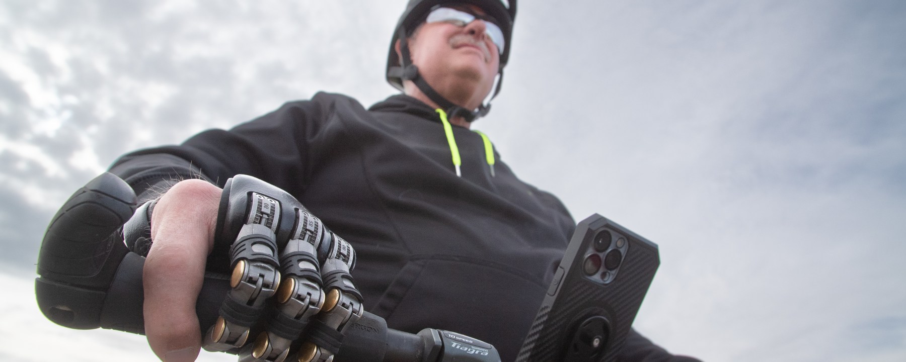 Man with Partial hand prosthetic holding handle of bike.