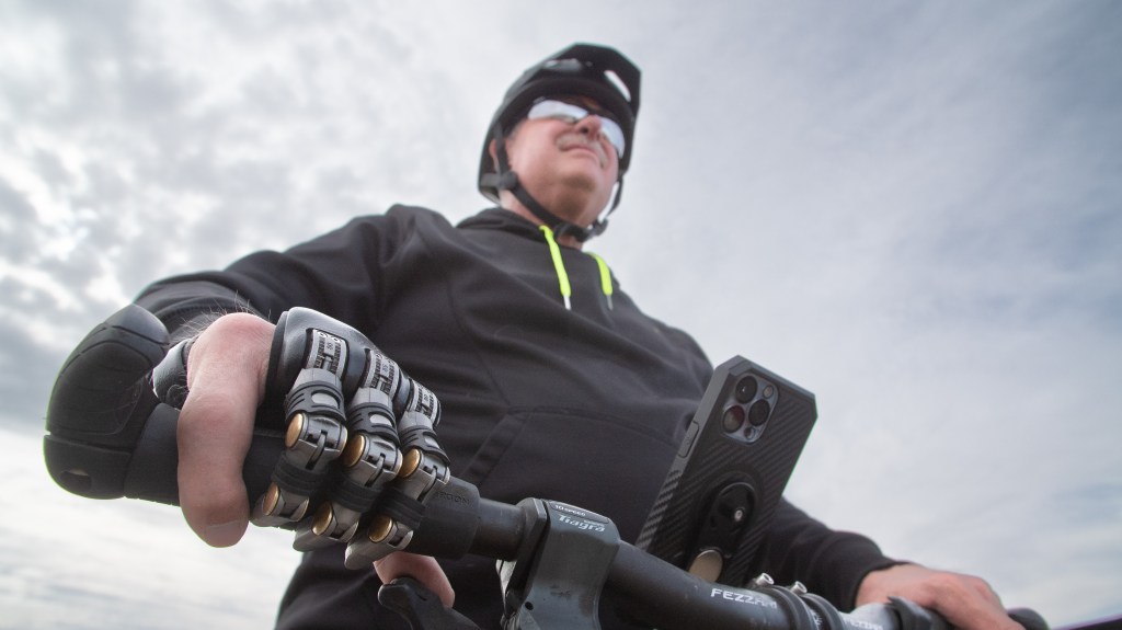 Man with Partial hand prosthetic holding handle of bike.