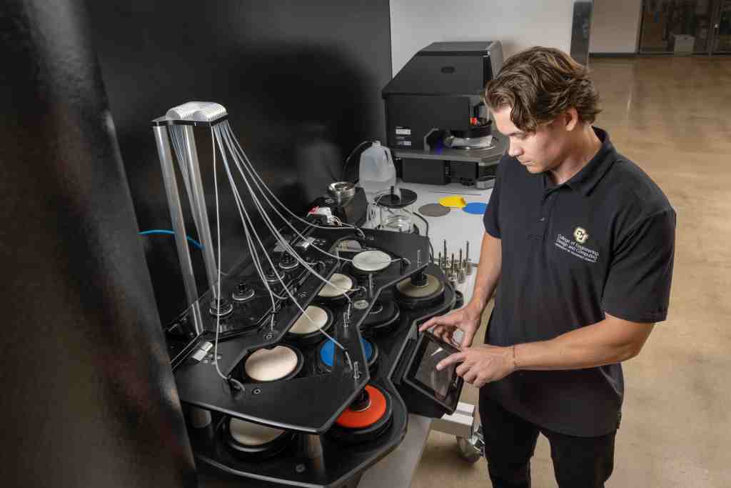 Trevor young at a machine in the oUtside lab